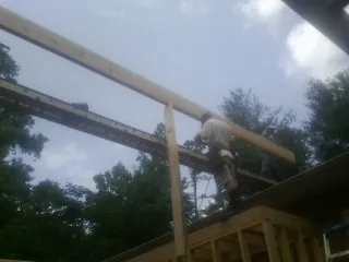Carpenter setting a ridge beam over a new addition frame — Ice Dam Removal by Roofing Brothers in Cottage Grove