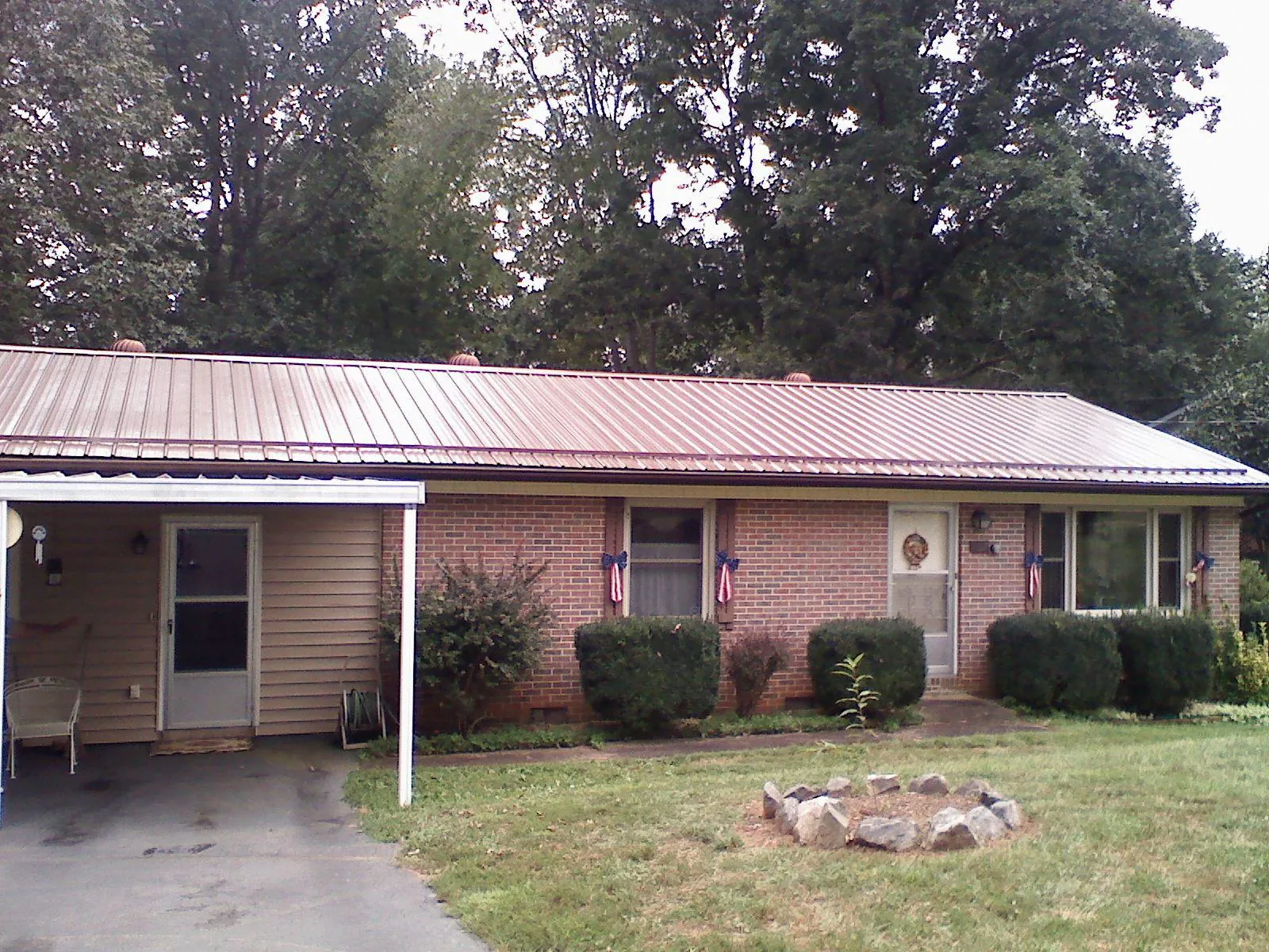 Bronze metal roof and carport on a brick ranch home — Roof Repair work by our crew in Cottage Grove
